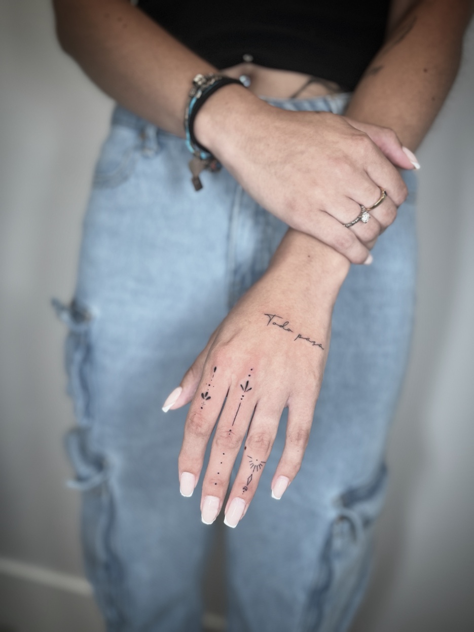 Fine line Todo Pasa script with ornamental finger tattoos