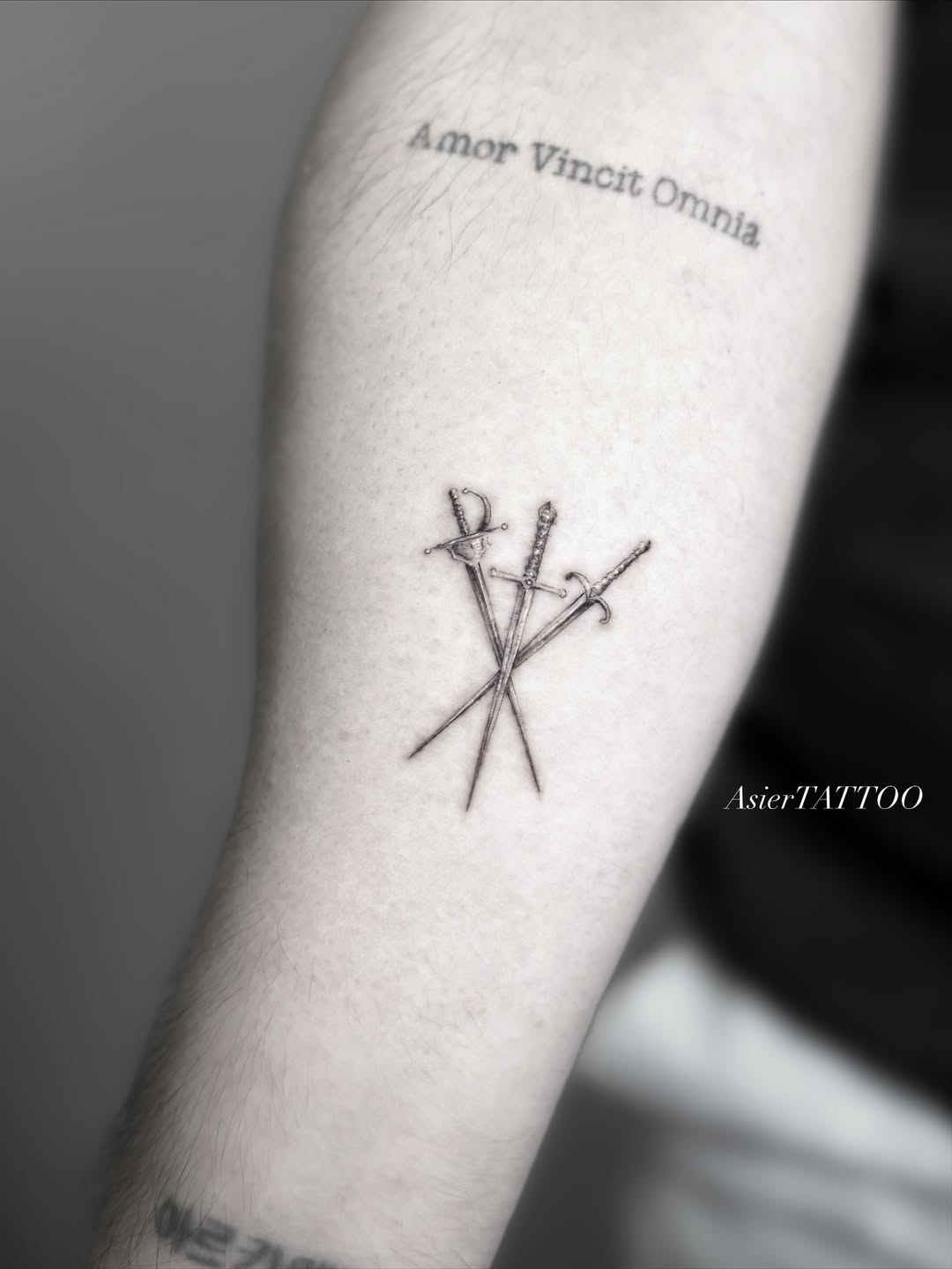 Fine line crossed swords script tattoo Orlando by AsierTATTOO